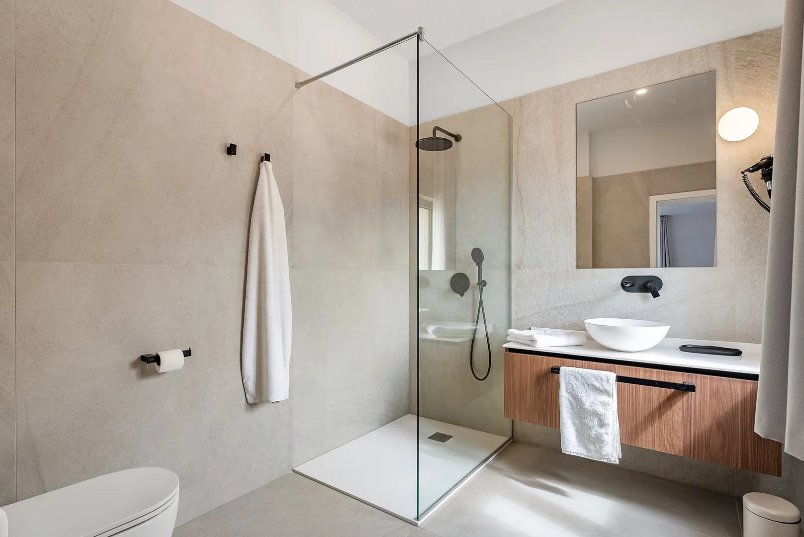 A modern bathroom with a glass shower and a sink vanity.