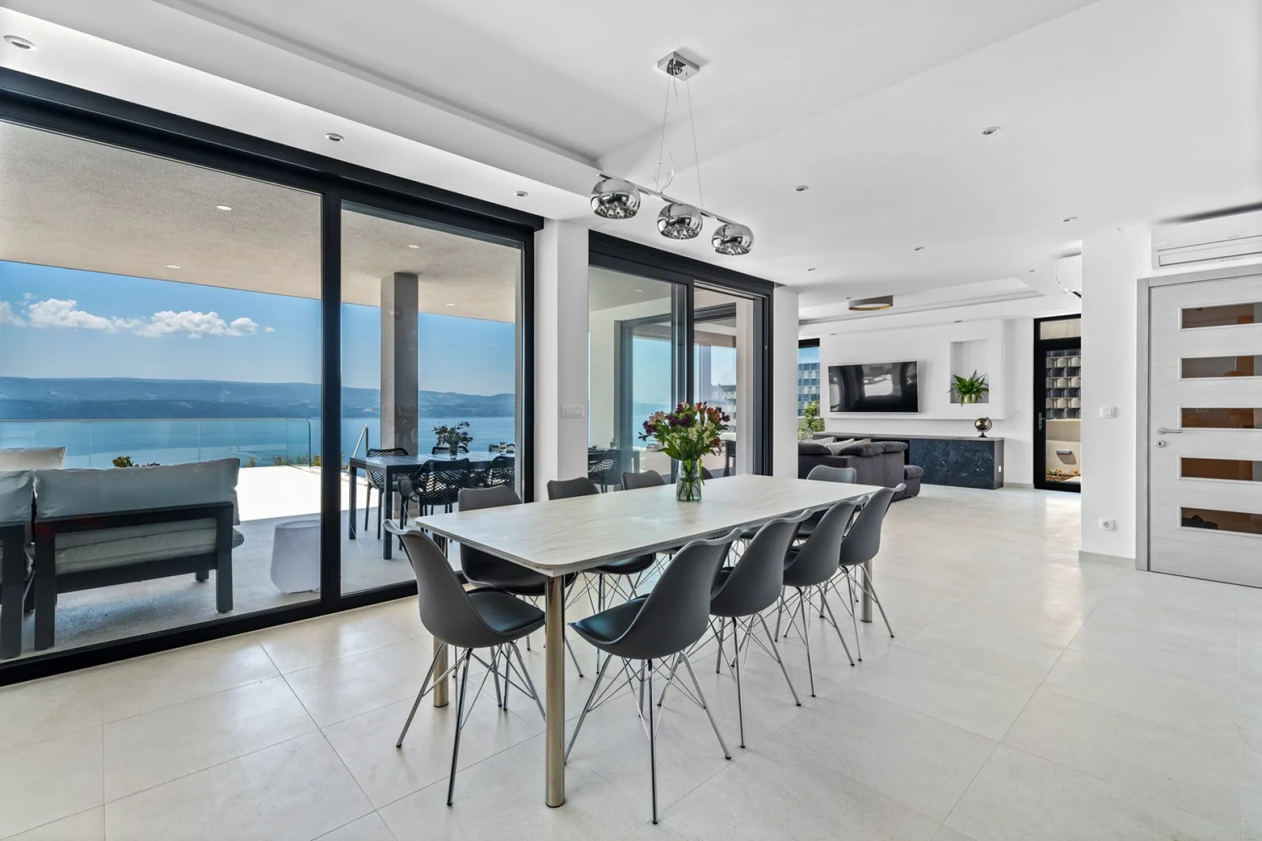 A bright open-plan dining and living area opens onto a terrace with ocean views.