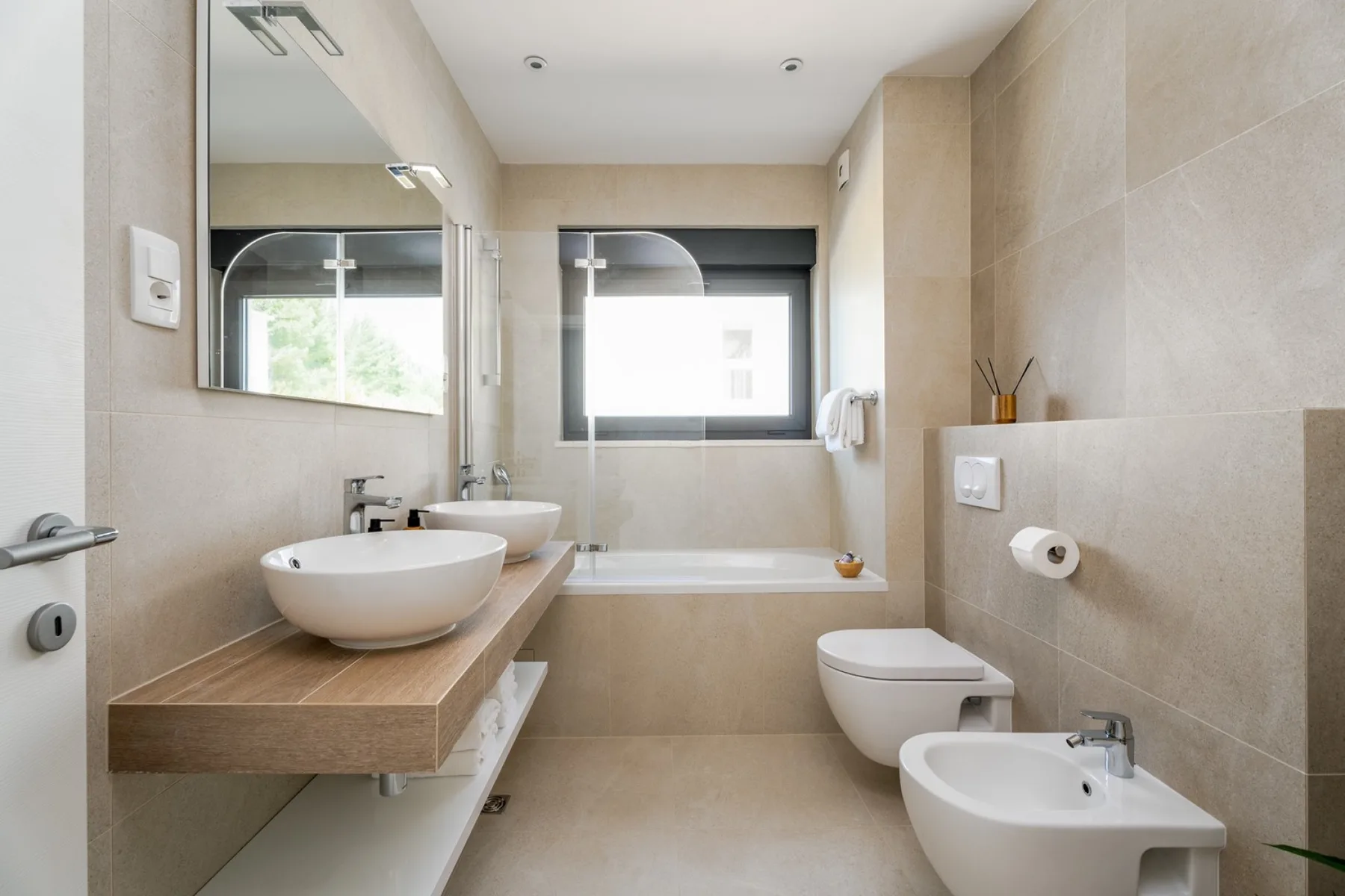 A modern bathroom with a bathtub, sink, and toilet.