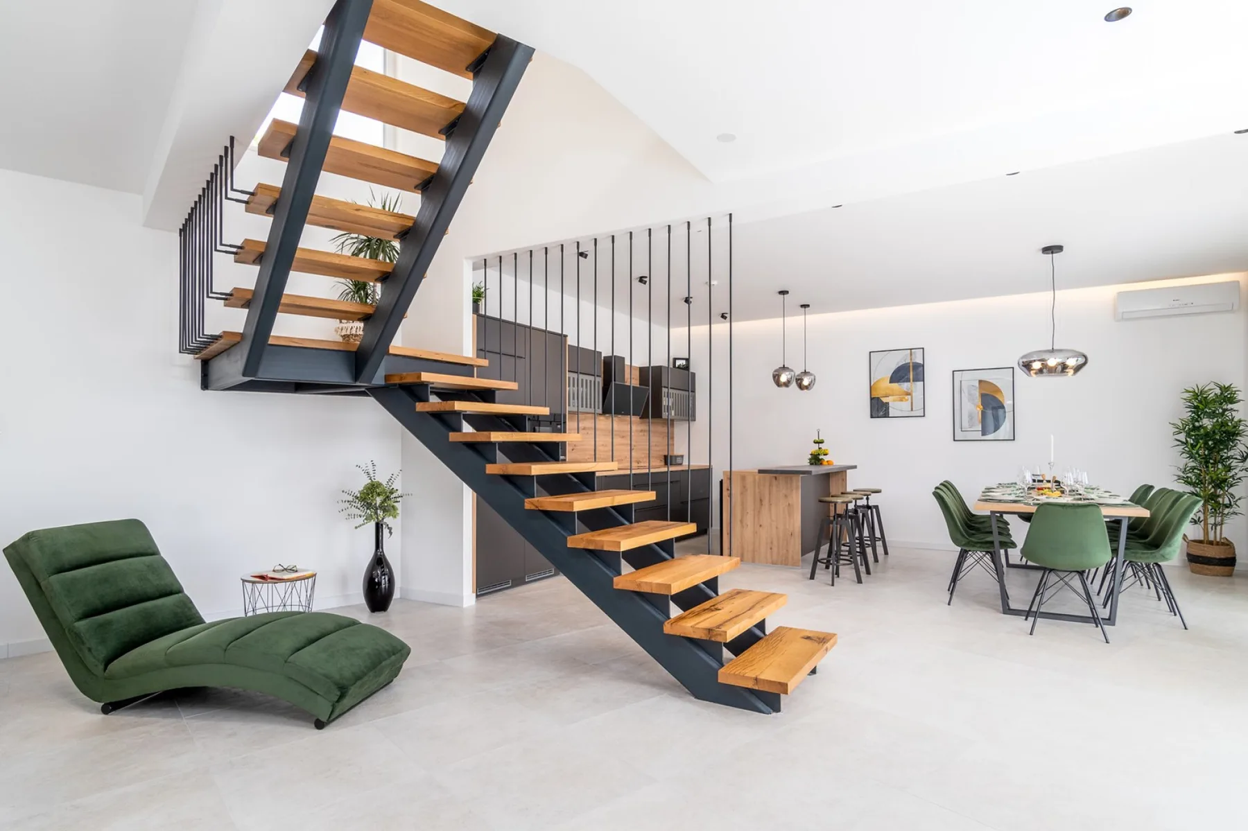 A bright open-plan living and dining area with a striking open staircase.