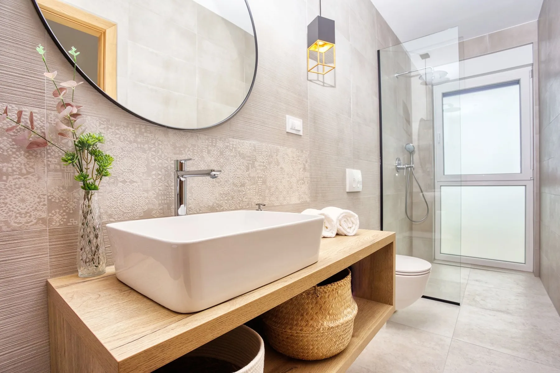 A modern bathroom with a vessel sink and glass shower.