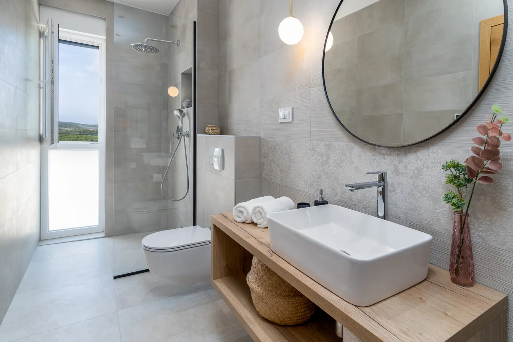 A modern bathroom with a vessel sink and a glass shower.