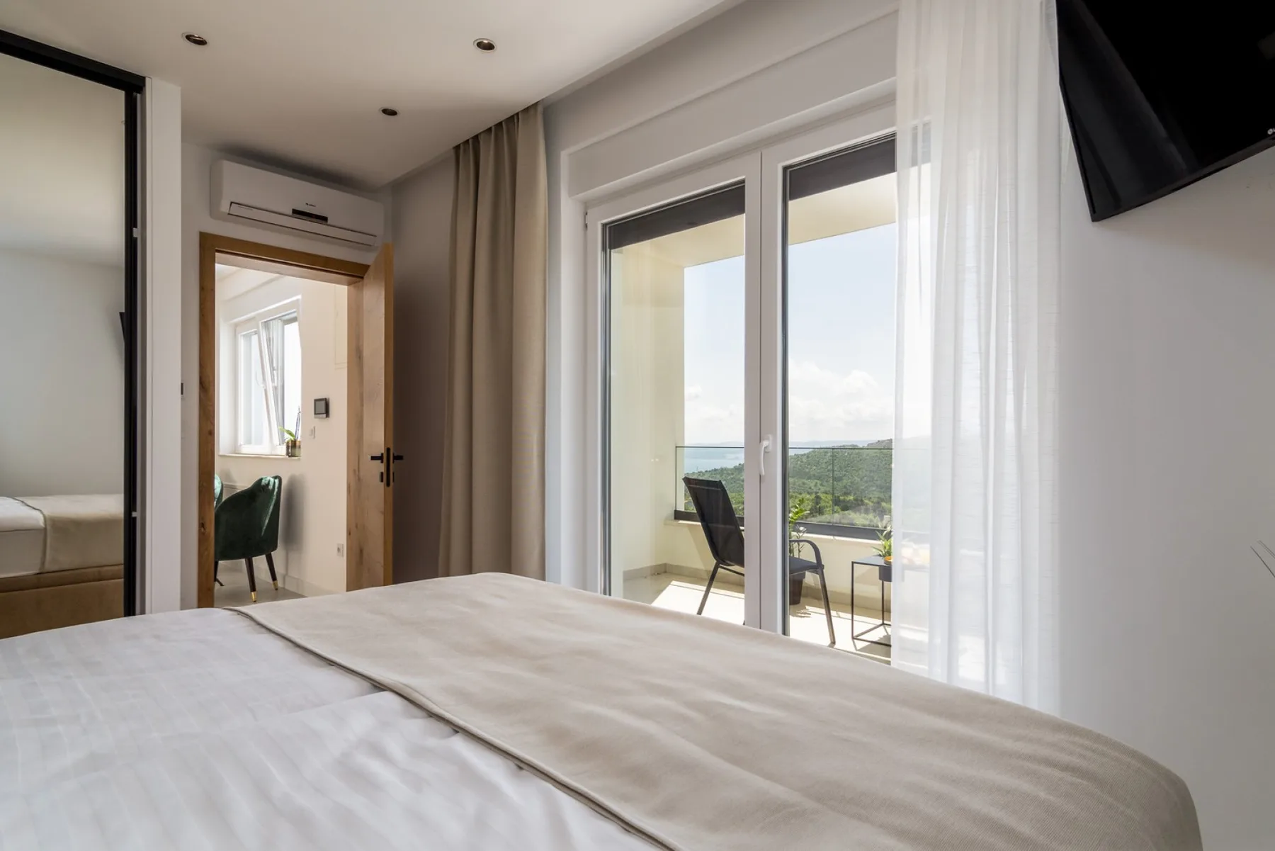 A bedroom with a bed beside glass doors opening onto a balcony.