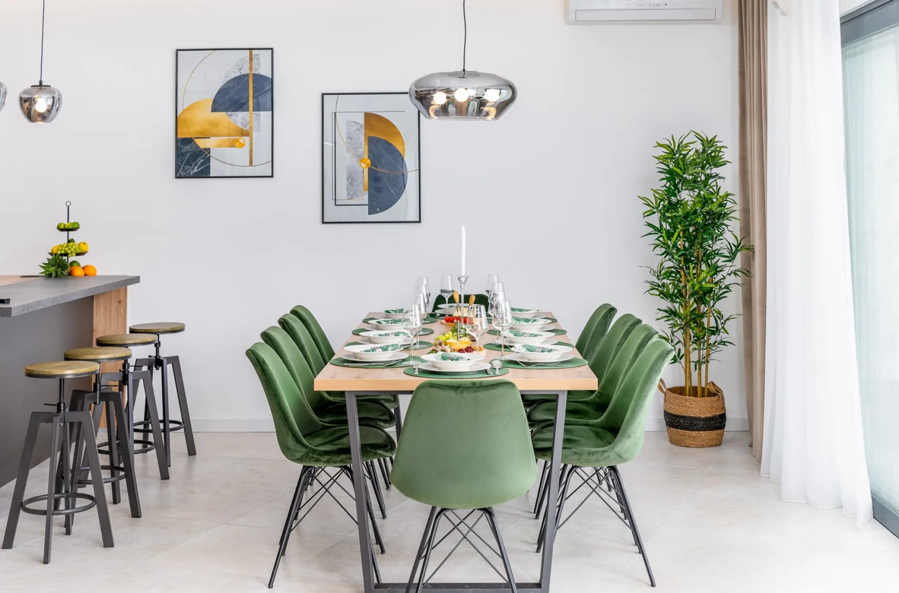 A dining area with a table set for a meal and green seating.