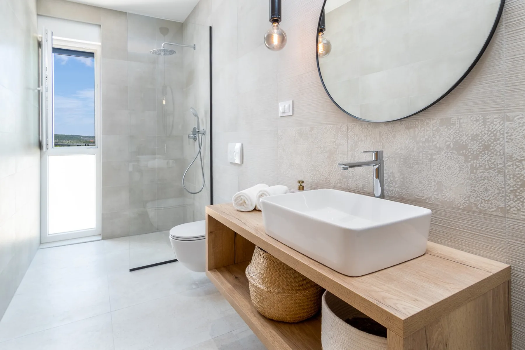 A bright modern bathroom with a walk-in shower and a vessel sink on a wooden vanity.