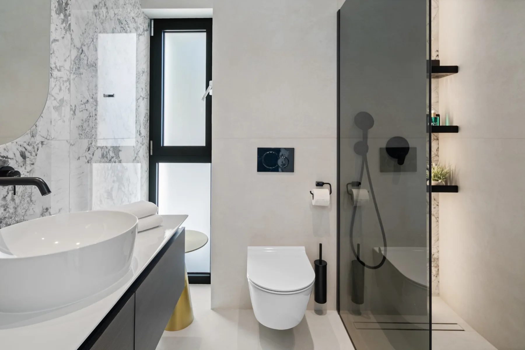 A modern bathroom with a sink, toilet, and glass-enclosed shower.