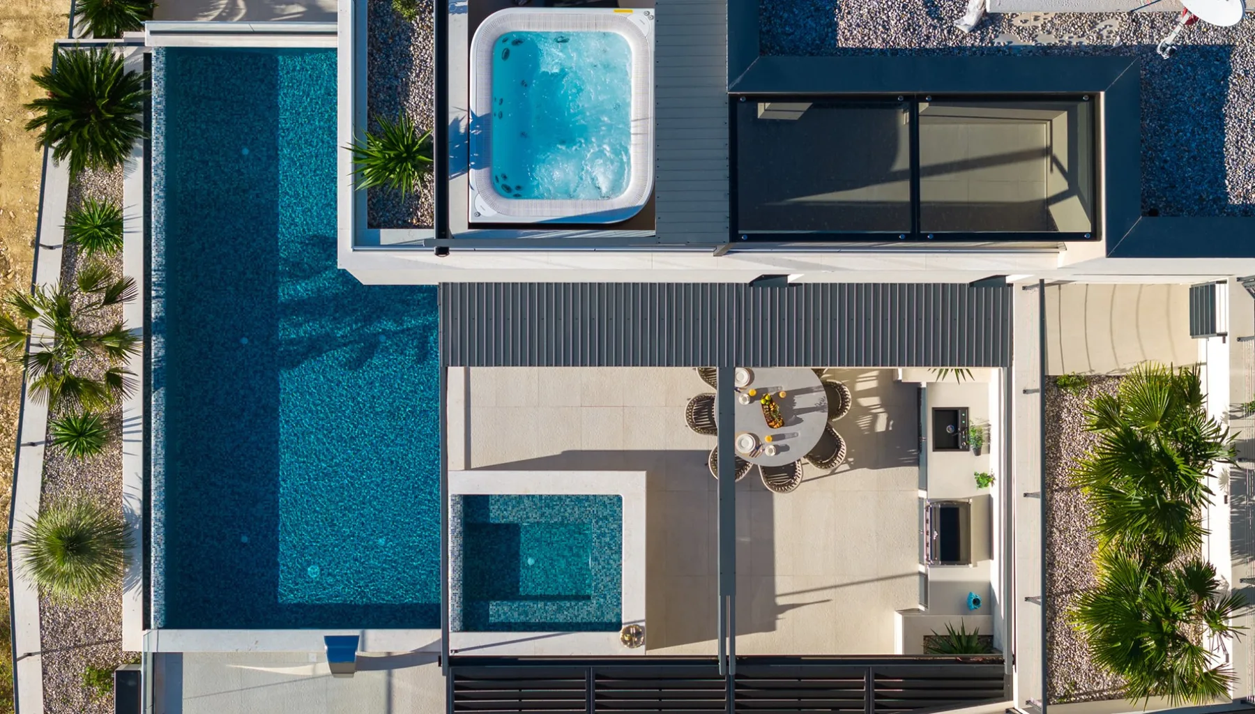 An overhead view shows a swimming pool beside a patio with seating.