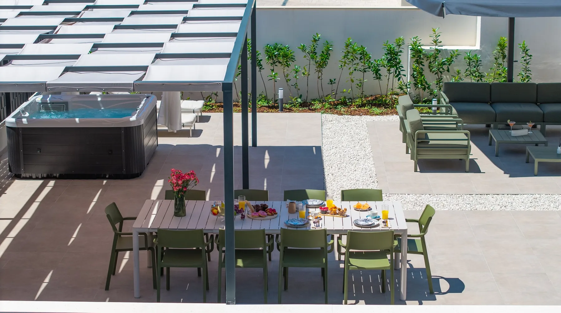 An outdoor dining area with a table beneath a pergola and lounge seating nearby.