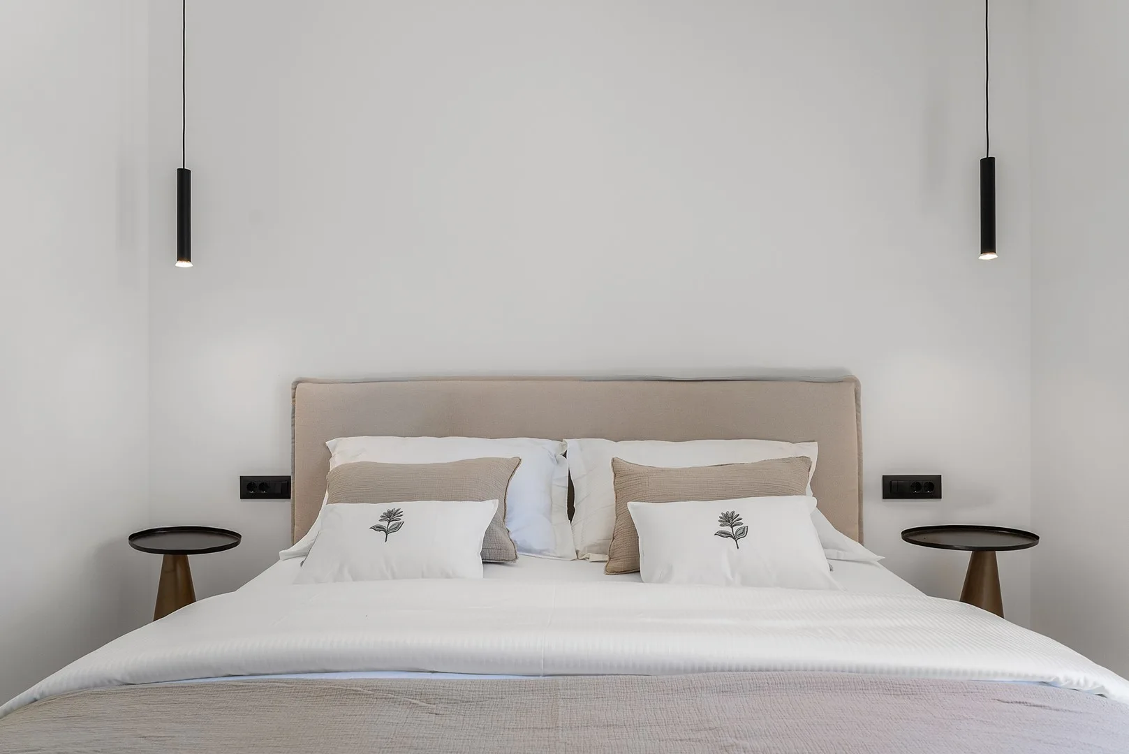 A bedroom with a neatly made bed and matching bedside tables.