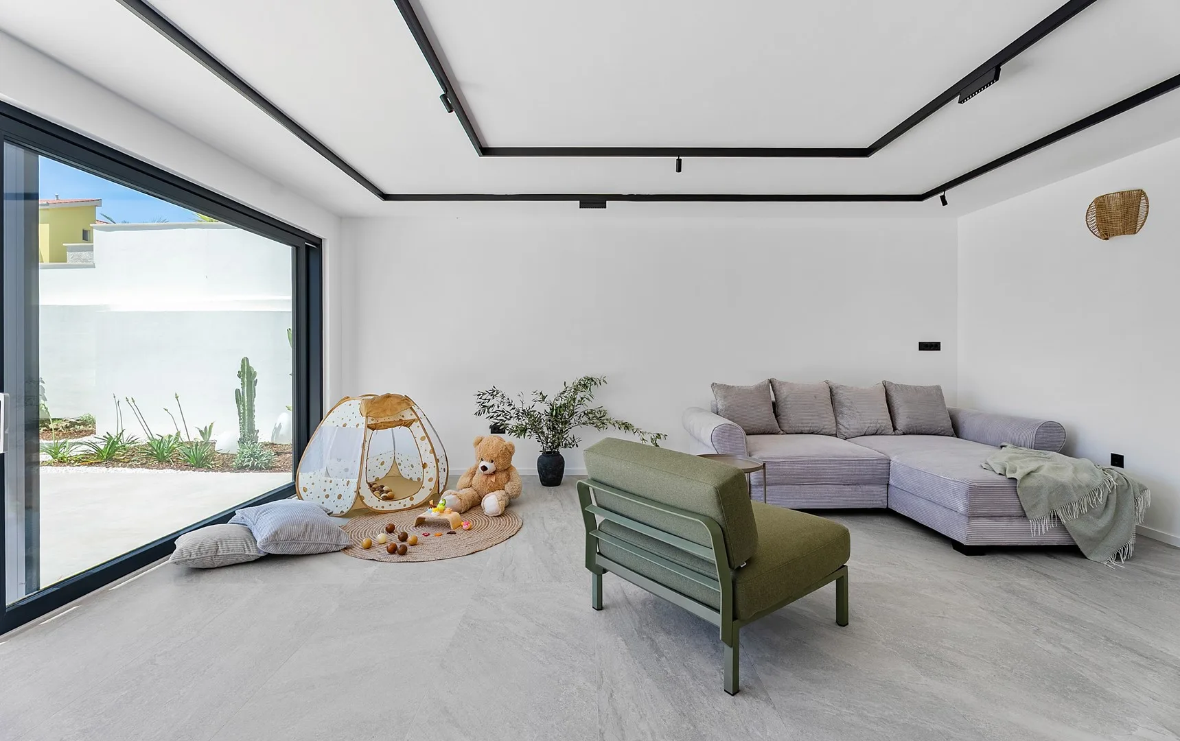 A bright living room with a sectional seating area and large sliding glass doors.