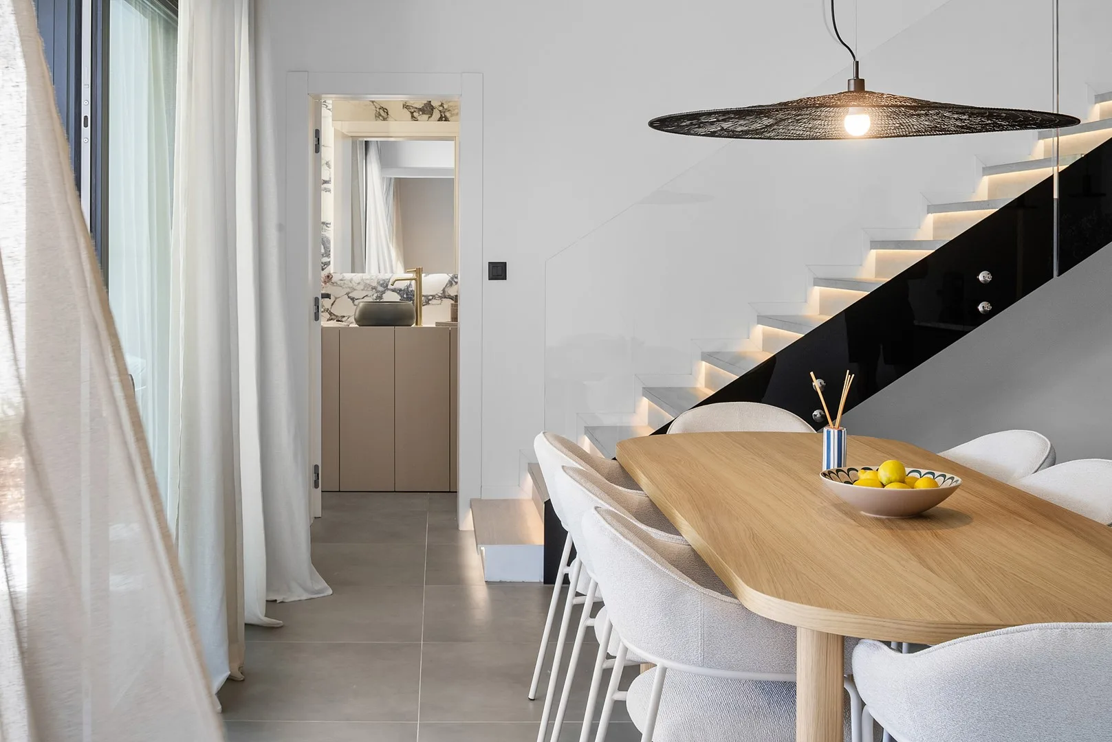 A dining area with a wooden table and seating beneath a pendant light.