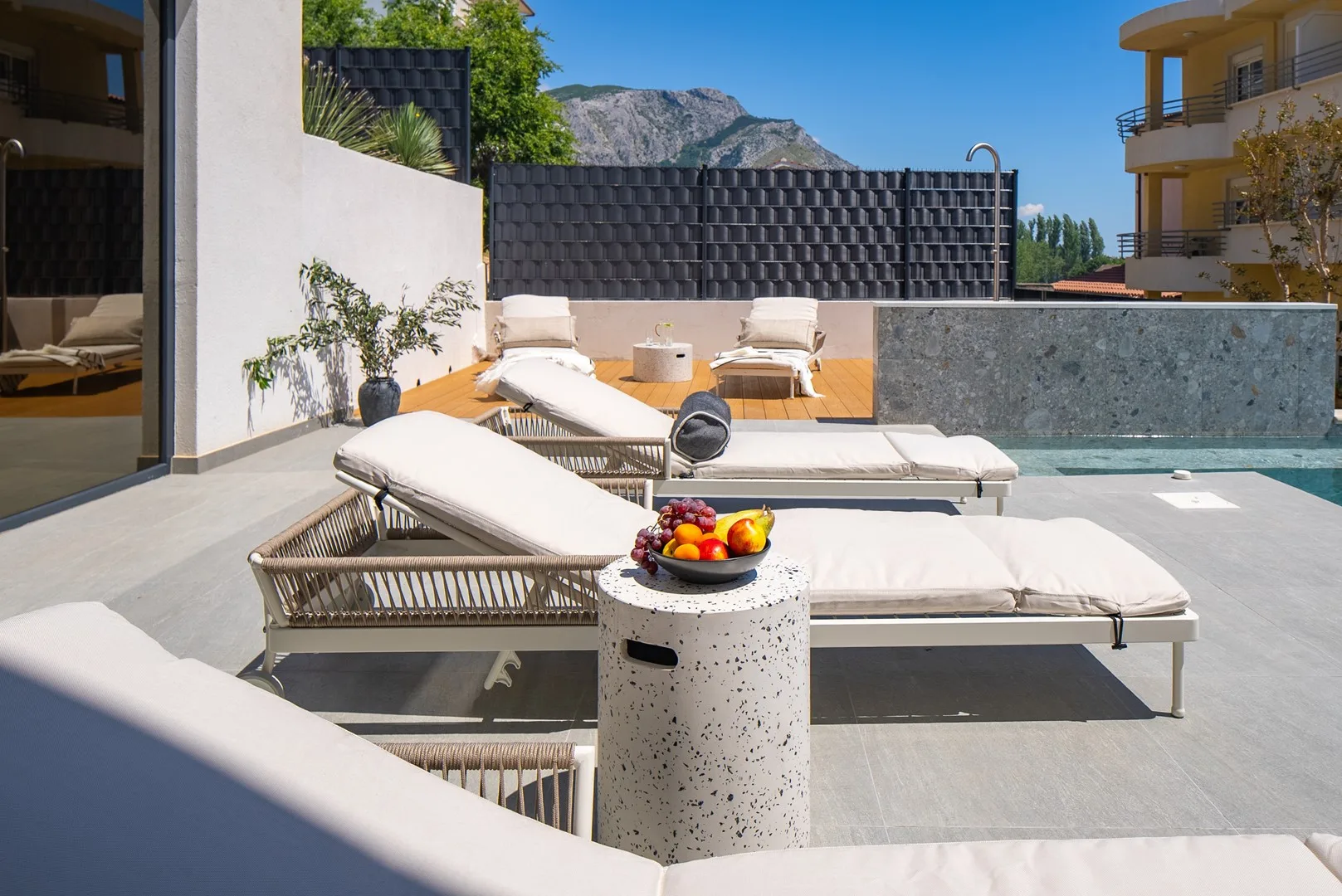 A rooftop terrace with cushioned loungers beside a small swimming pool.