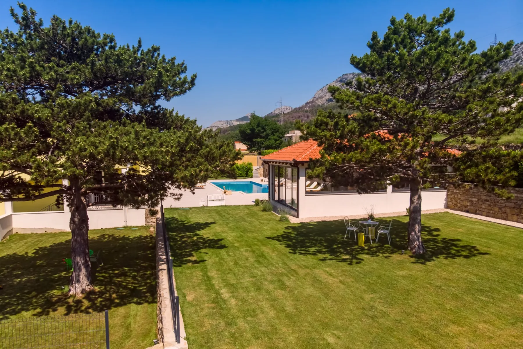 Un jardín con piscina y árboles.