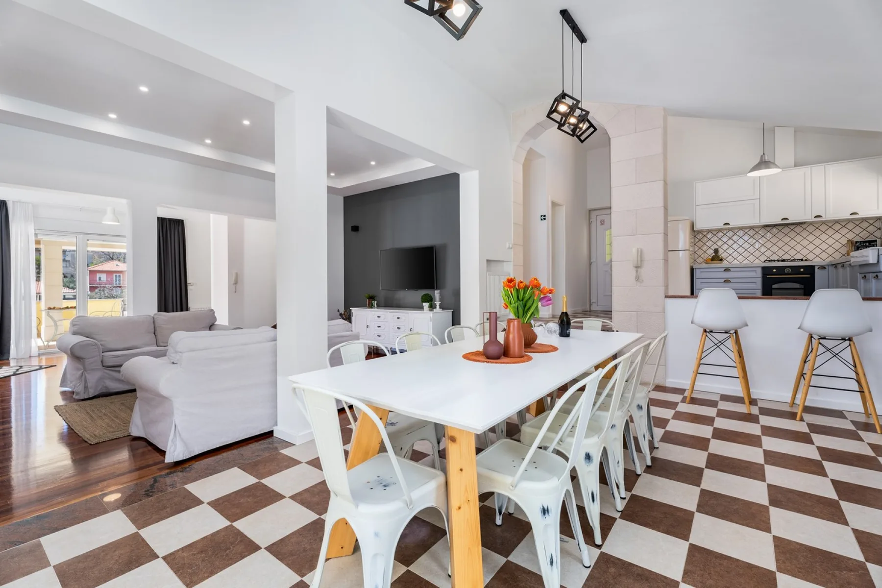 Una luminosa zona abierta de comedor y cocina con una mesa blanca y asientos.