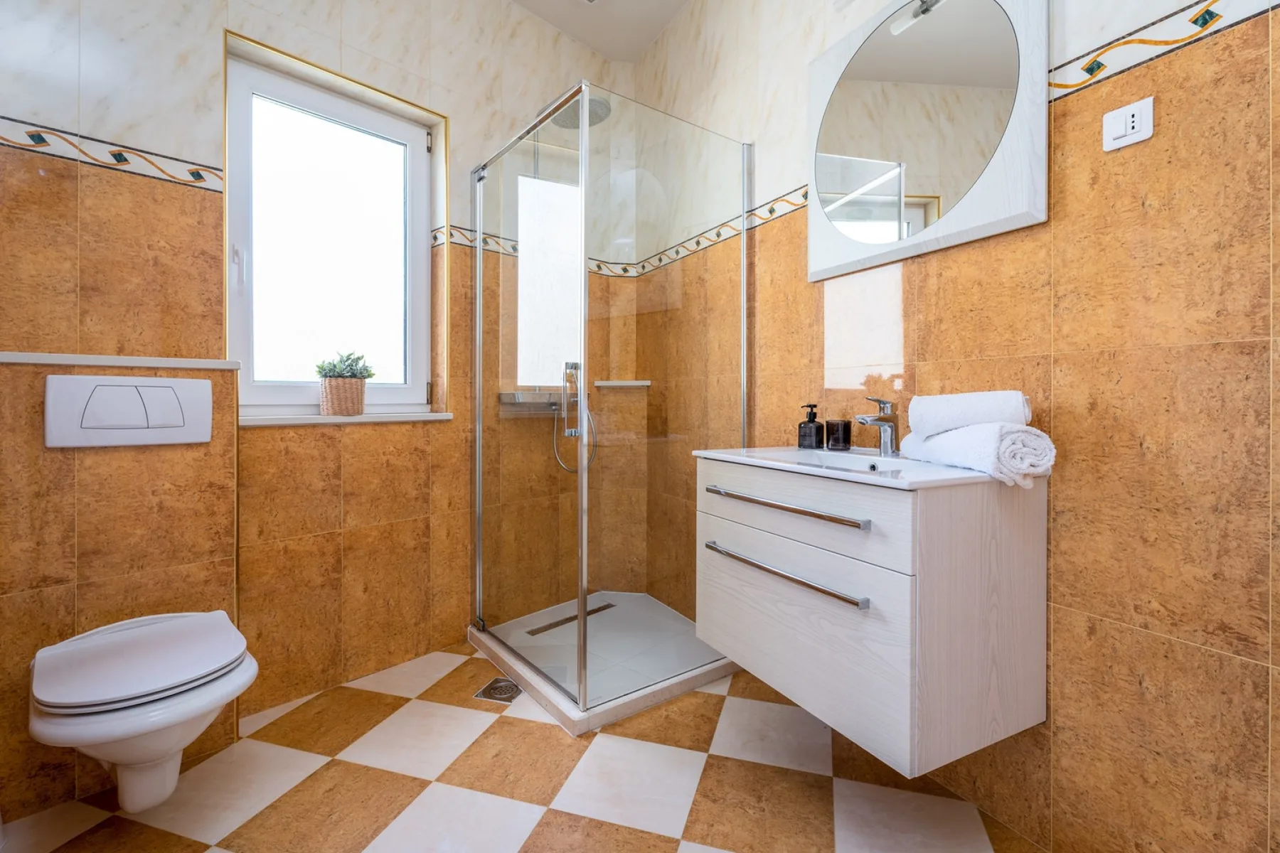 Un baño con una ducha de vidrio y un lavabo suspendido.