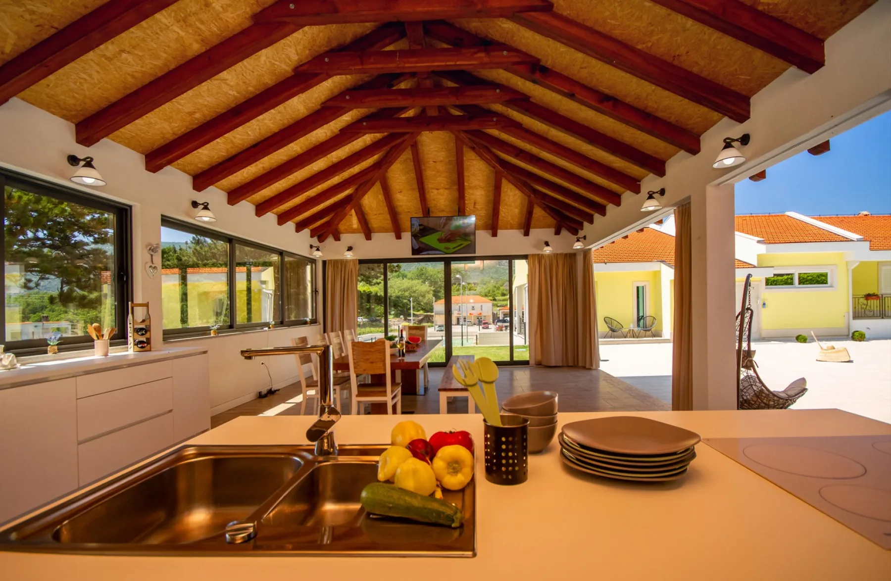 Una cocina amplia con una isla central y grandes ventanas con vistas al patio.