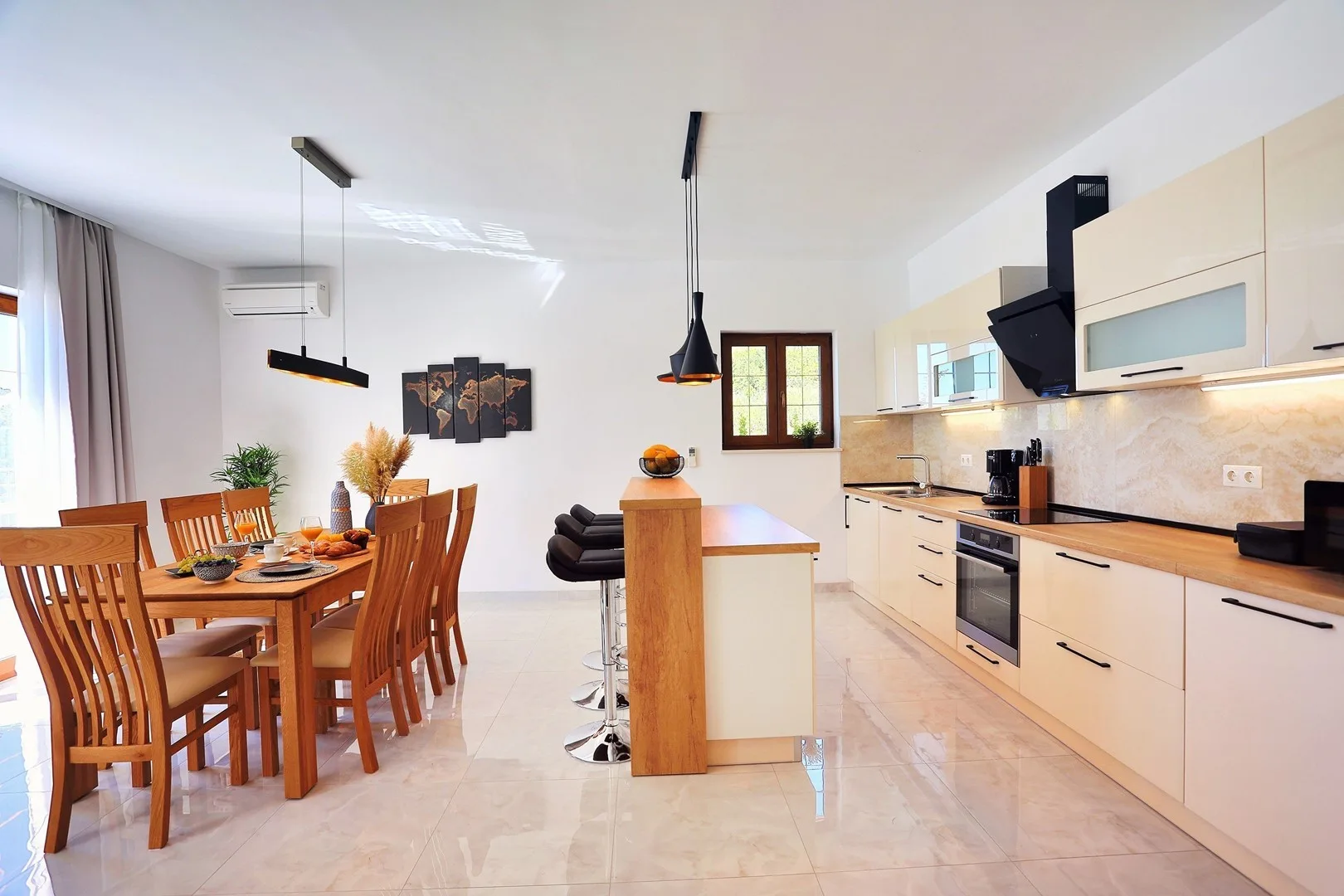 A bright kitchen and dining area with a wooden table and pale cabinets.