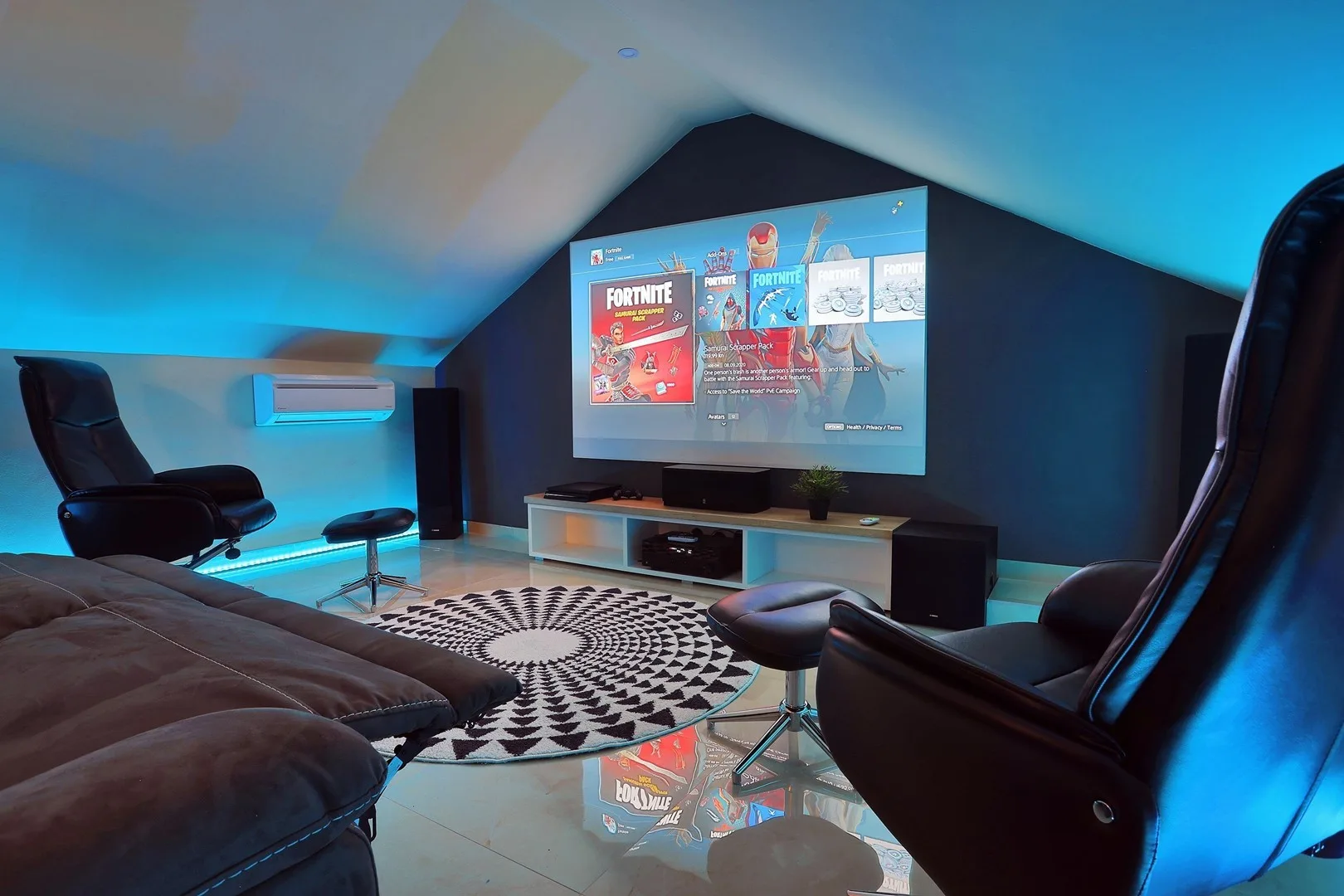 A media room with a large projected screen and seating arranged around it.