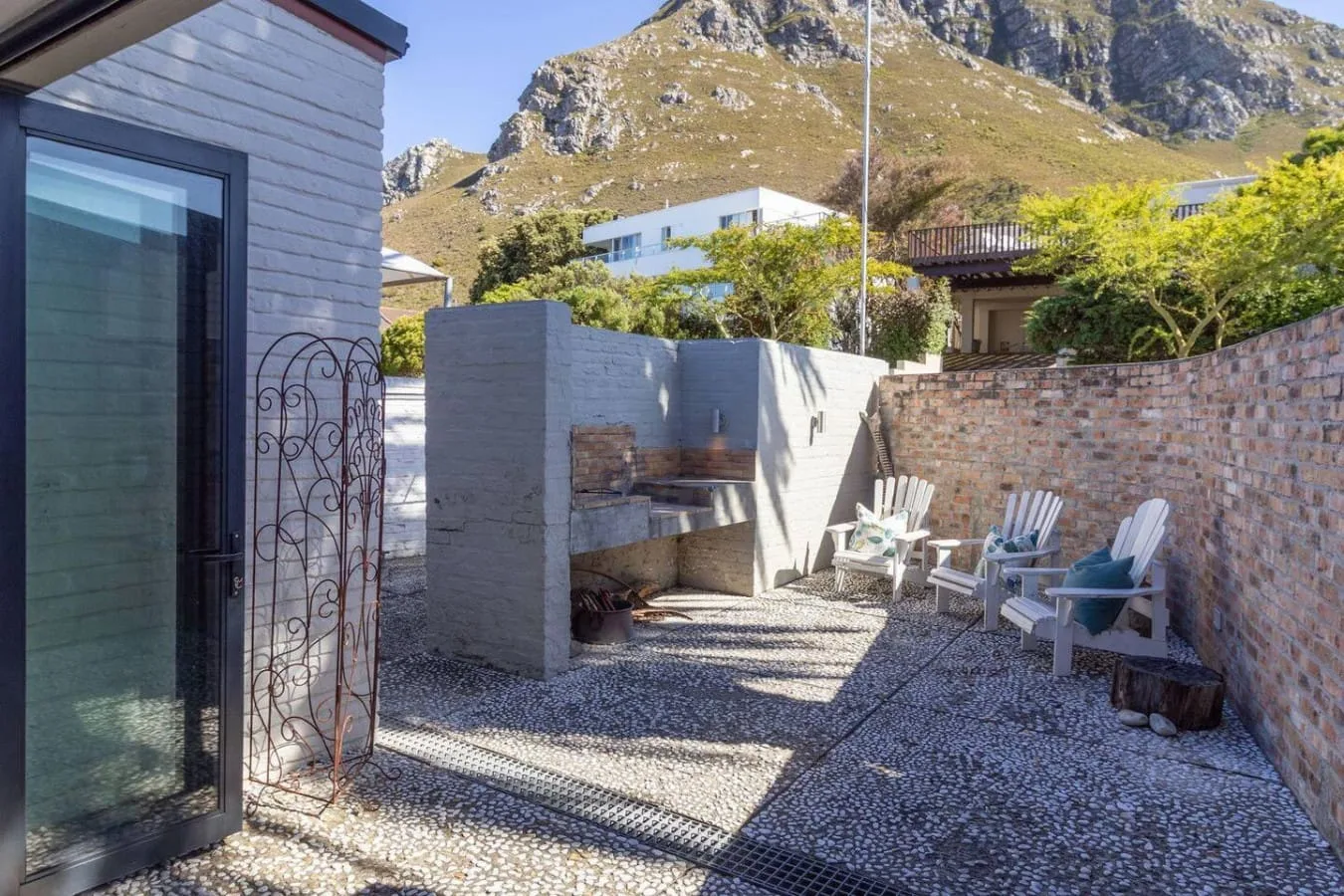 A stone-paved outdoor patio with seating and a built-in grill.
