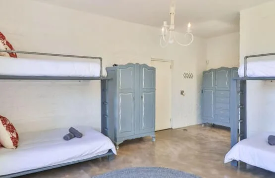 A bedroom with bunk beds and blue wardrobes.