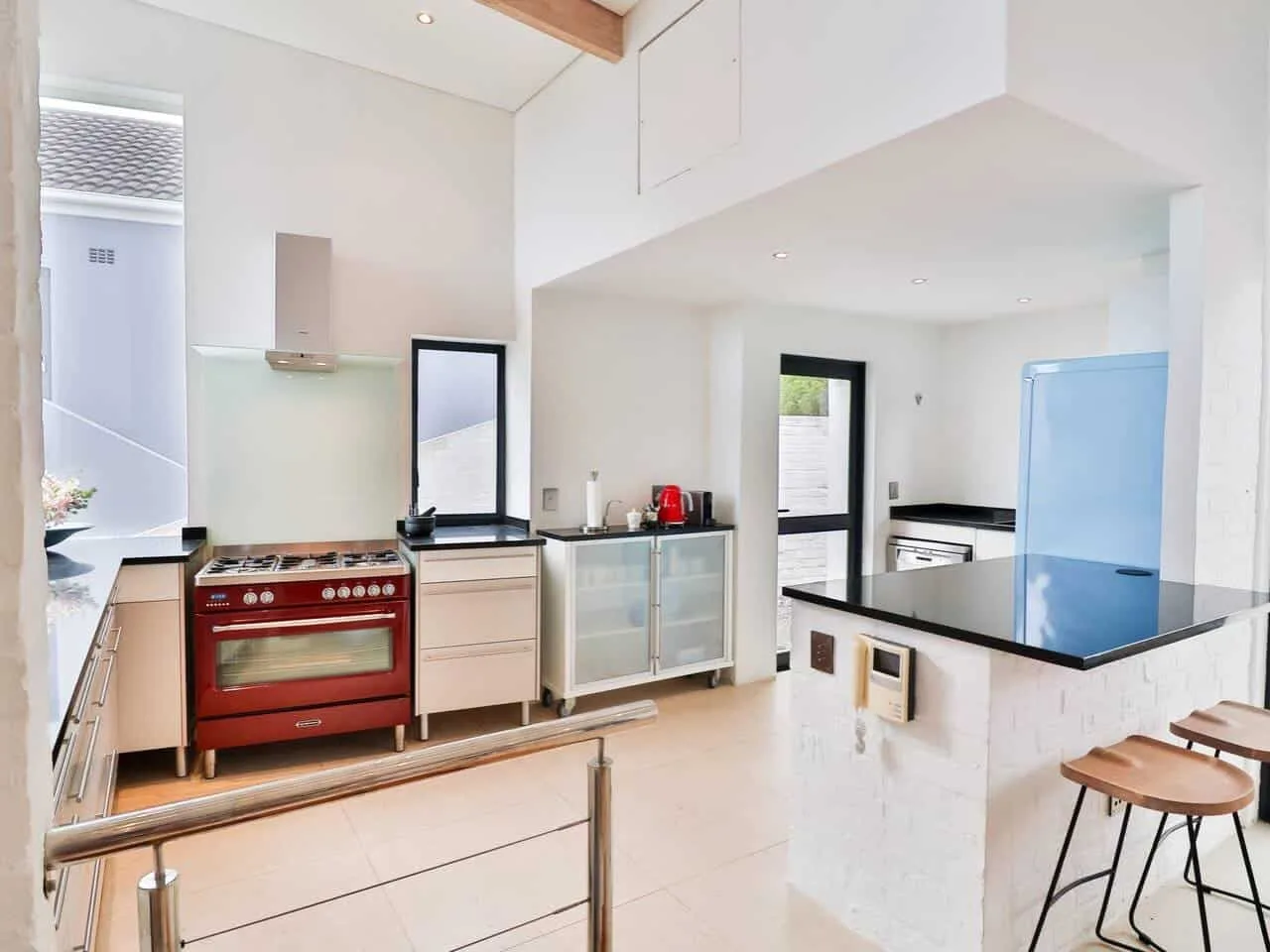 A bright kitchen with a red range and a counter separating the cooking area.