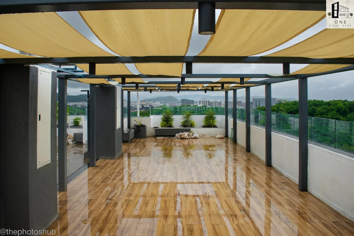 Zona común: Una terraza cubierta en la azotea, con suelo brillante y macetas junto al borde.