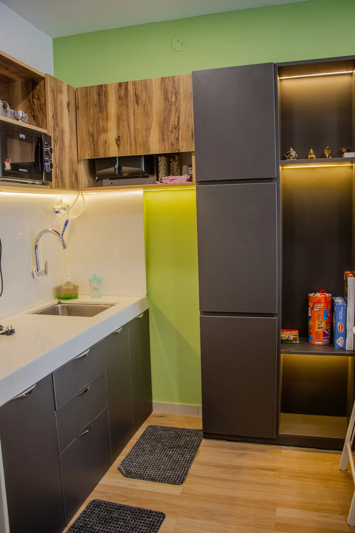 Una cocina compacta con armarios de madera, muebles oscuros y un fregadero.