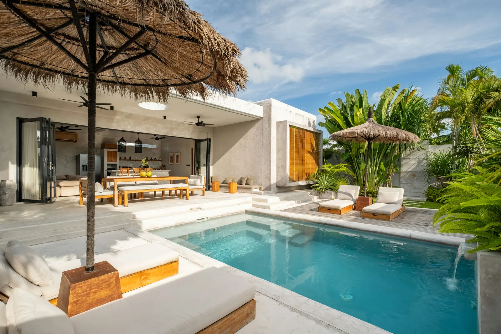 Outdoor pool beside a modern open-air dining area with lounge seating.