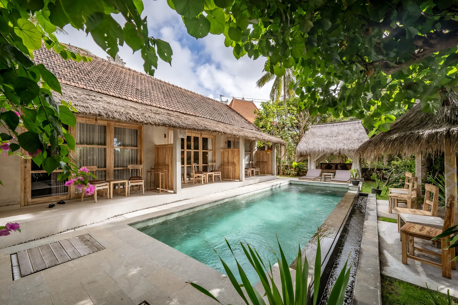Shared amenity: A courtyard pool sits beside a low building and shaded seating.