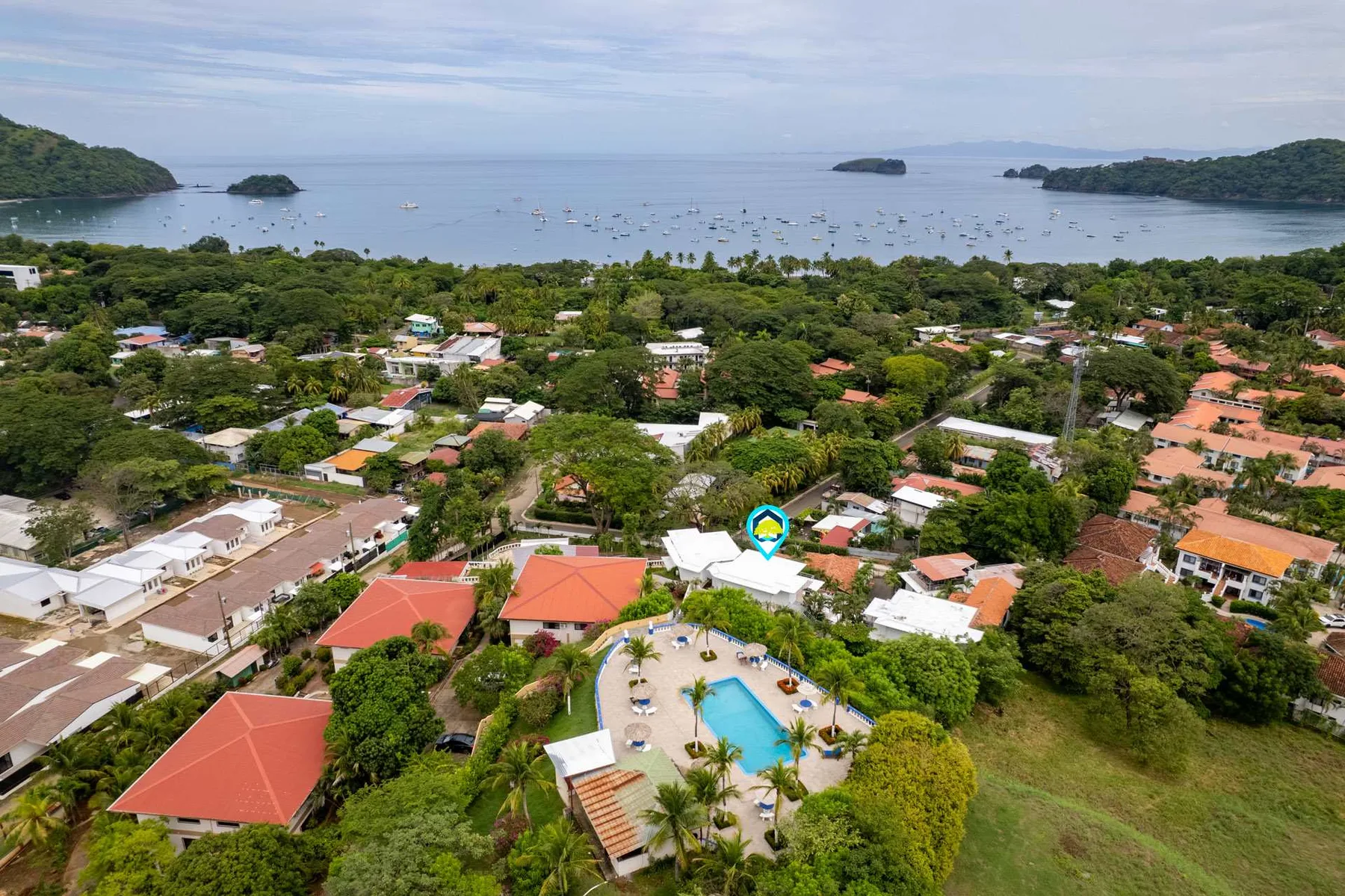 Shared amenity: Aerial view of a coastal neighborhood with a pool among the buildings.