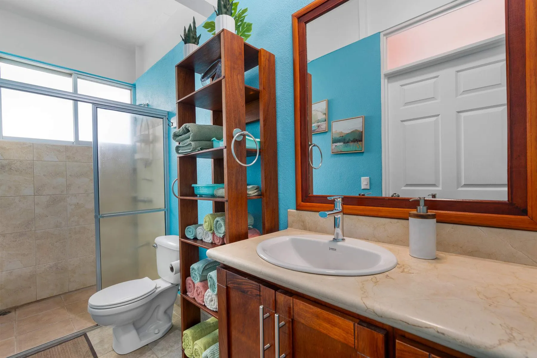 A bathroom with a sink, toilet, and glass shower.