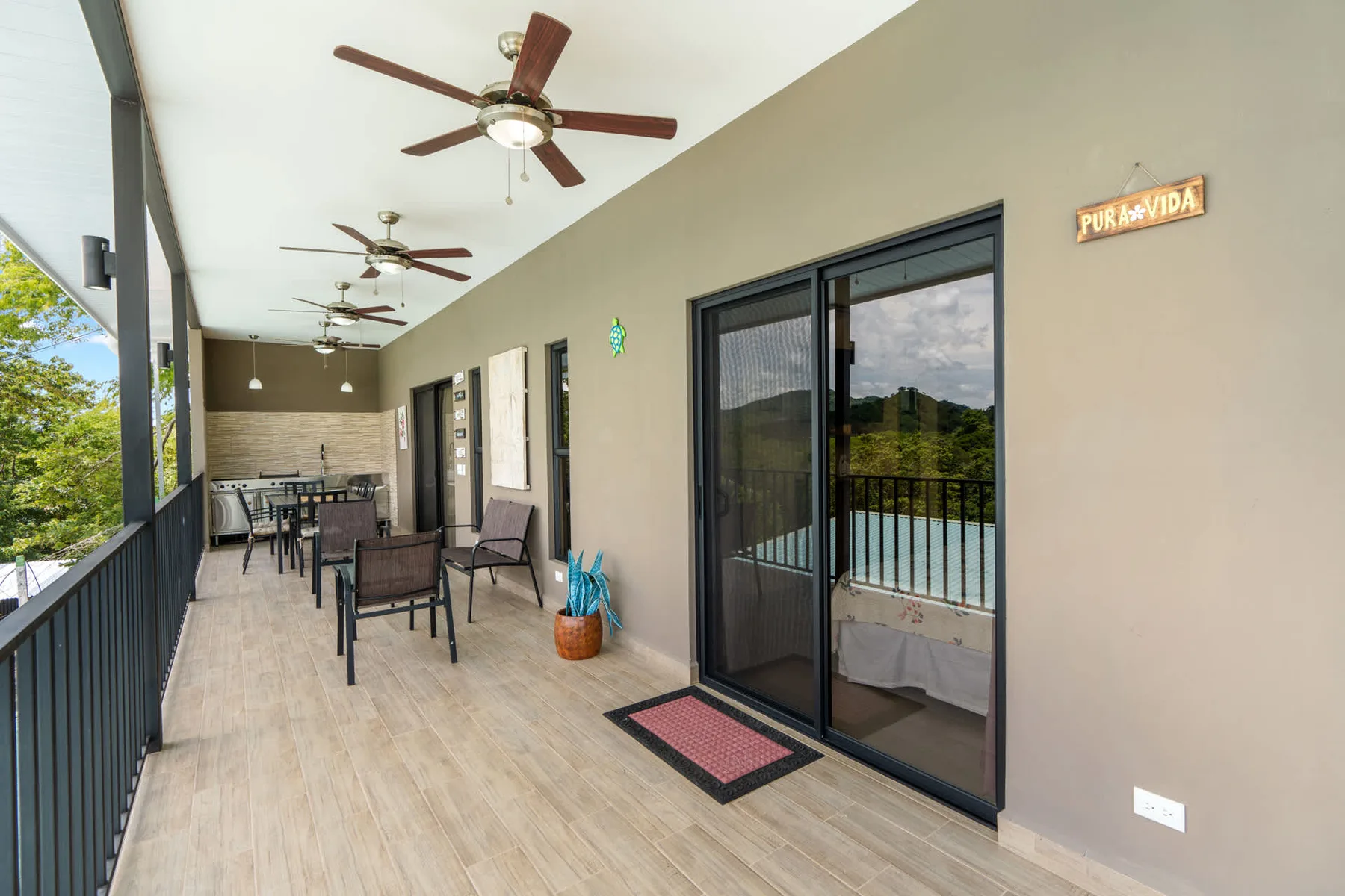 A covered patio with outdoor seating and sliding glass doors.