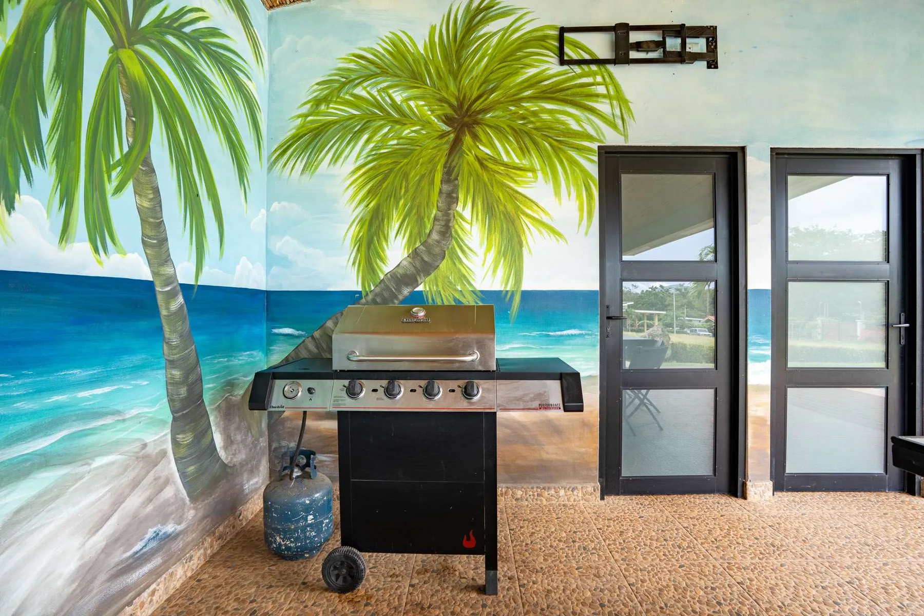 Shared amenity: A barbecue grill stands in front of a tropical beach mural.