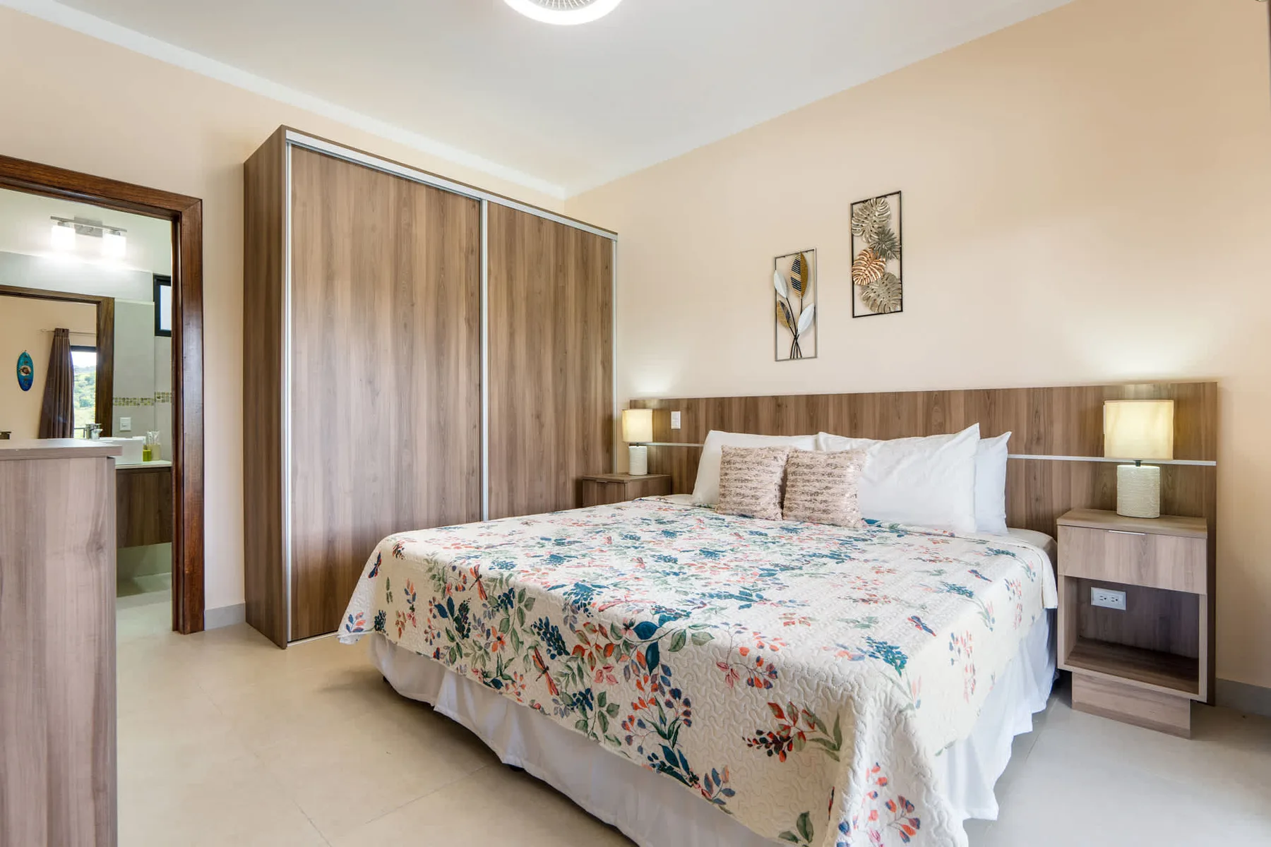 A bedroom with a double bed, bedside tables, and a large wardrobe.