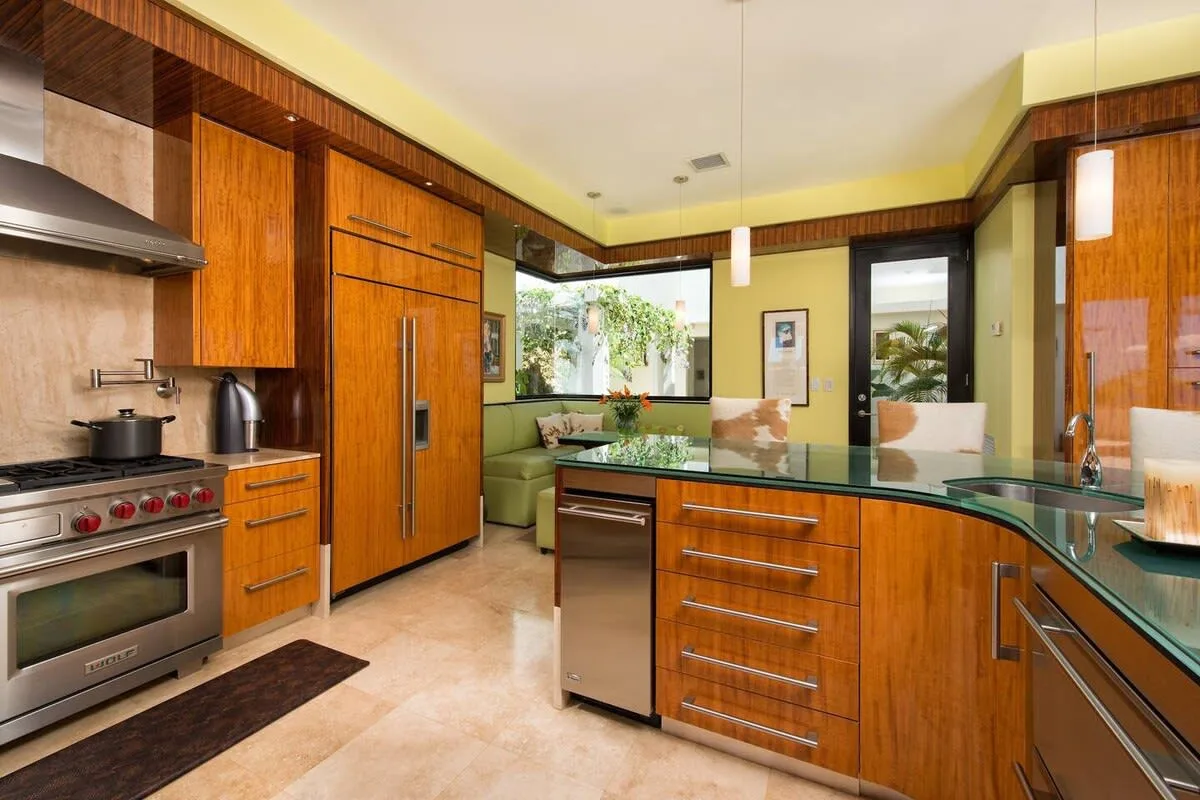 A modern kitchen with wood cabinetry, a cooking range, and a central island.