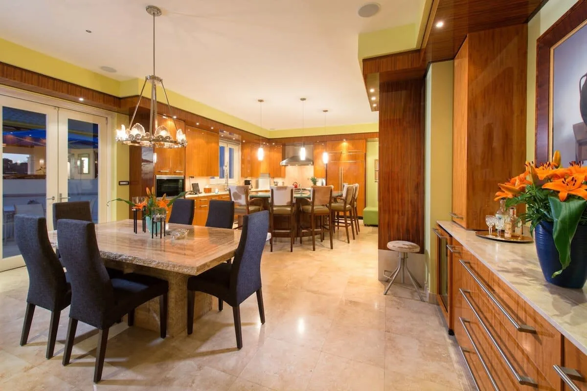 A spacious kitchen and dining area with a table, chairs, and warm wood cabinetry.
