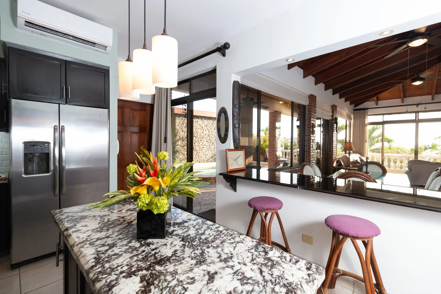 A bright kitchen with a stone-patterned island and views into the dining area.