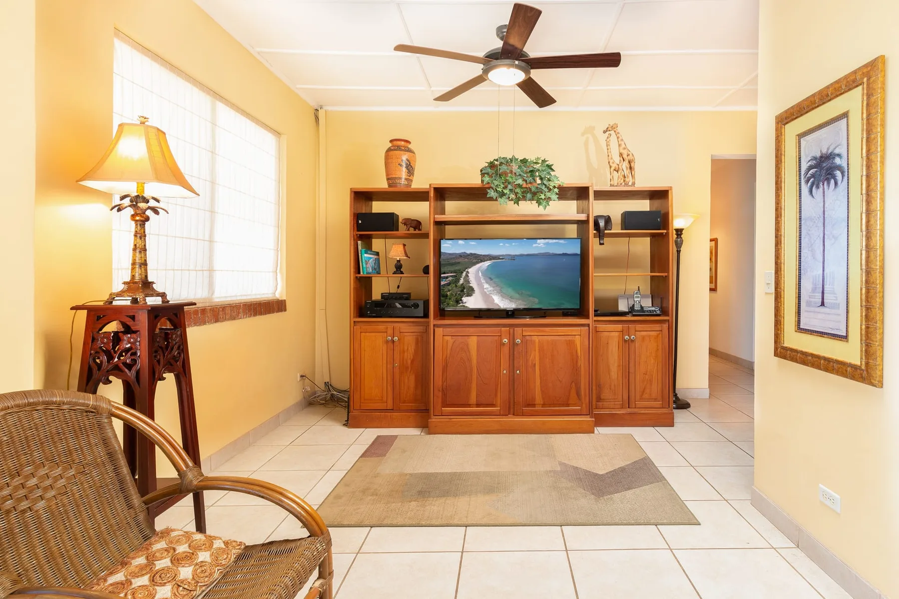 A living room with a television in a wooden entertainment center and seating nearby.