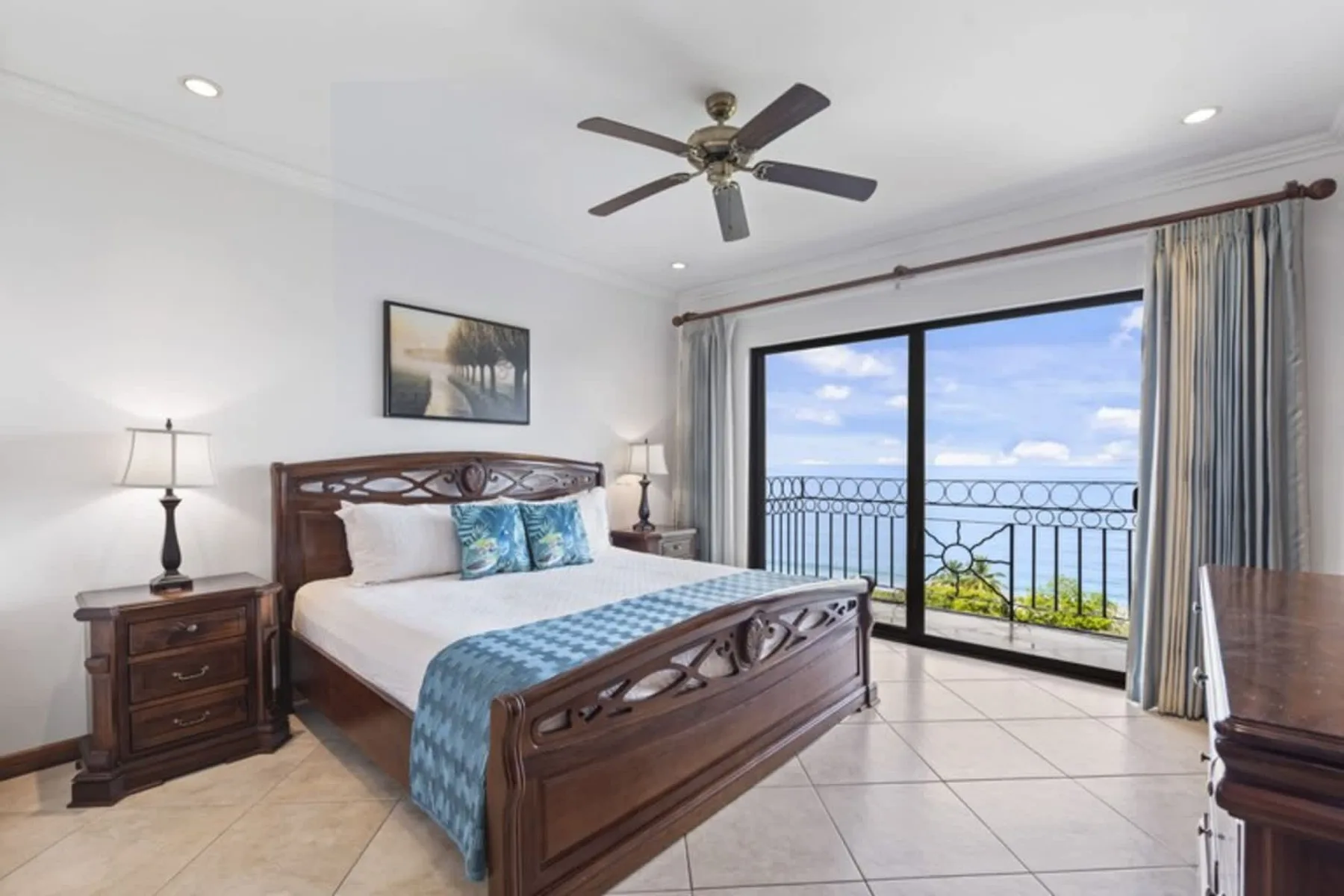 A bedroom with a large bed and sliding glass doors opening onto a balcony.