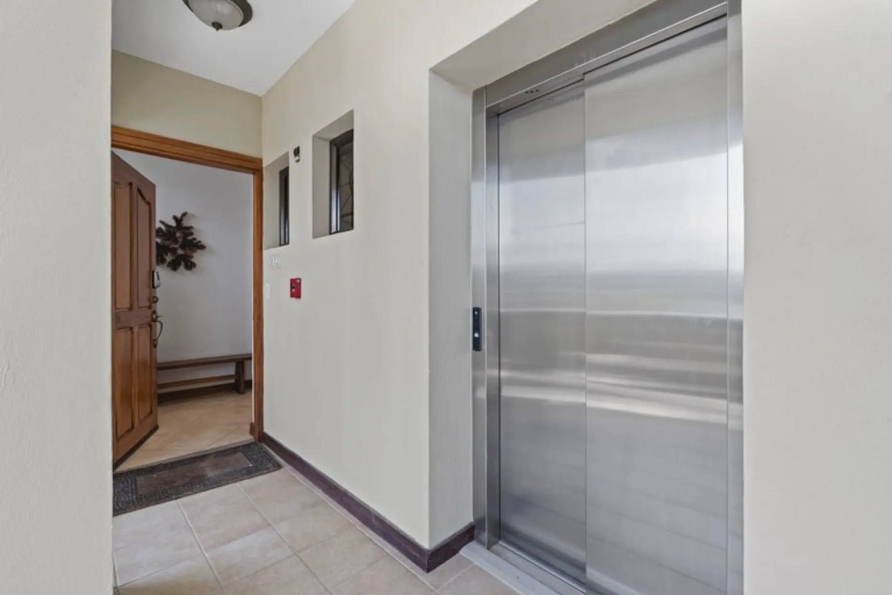 Shared amenity: An elevator entrance beside an open hallway.