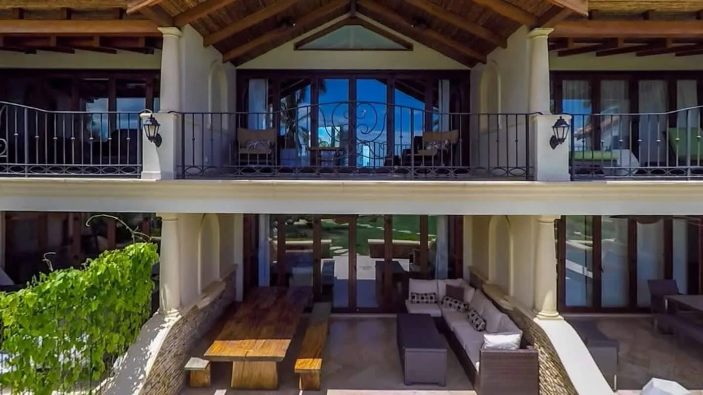 A two-level covered patio with seating and a wooden dining table.