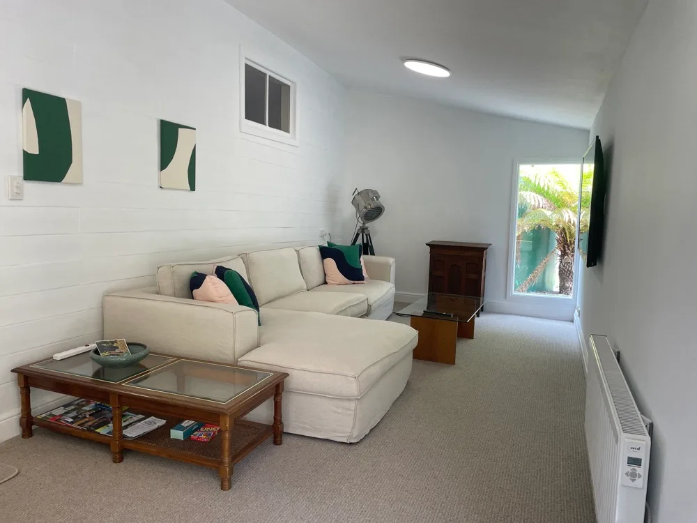 A living room with sectional seating, a coffee table, and a window.