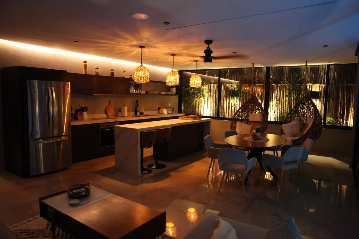 Cocina y comedor de concepto abierto con una isla central y una mesa redonda.