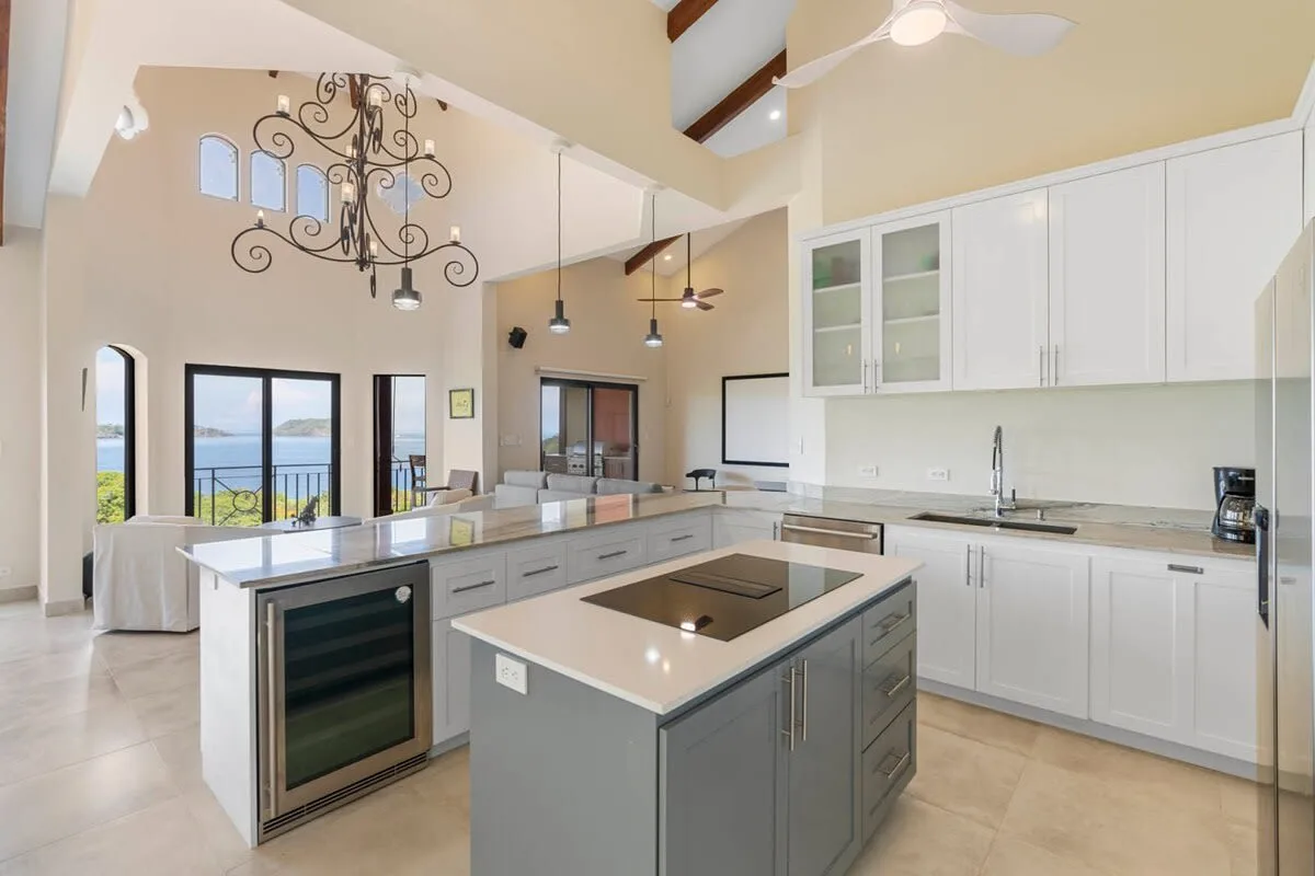 A bright kitchen with a large island and white cabinets.