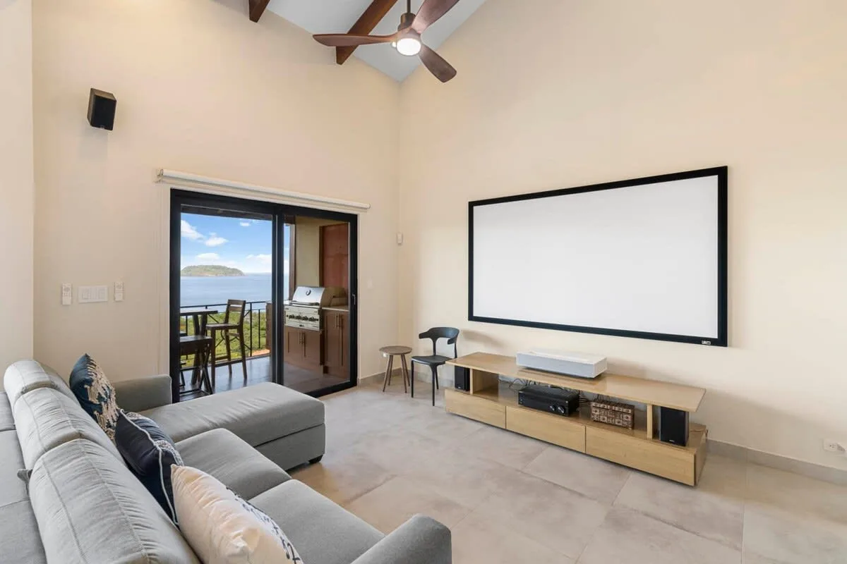 A living room with a large projection screen and seating.