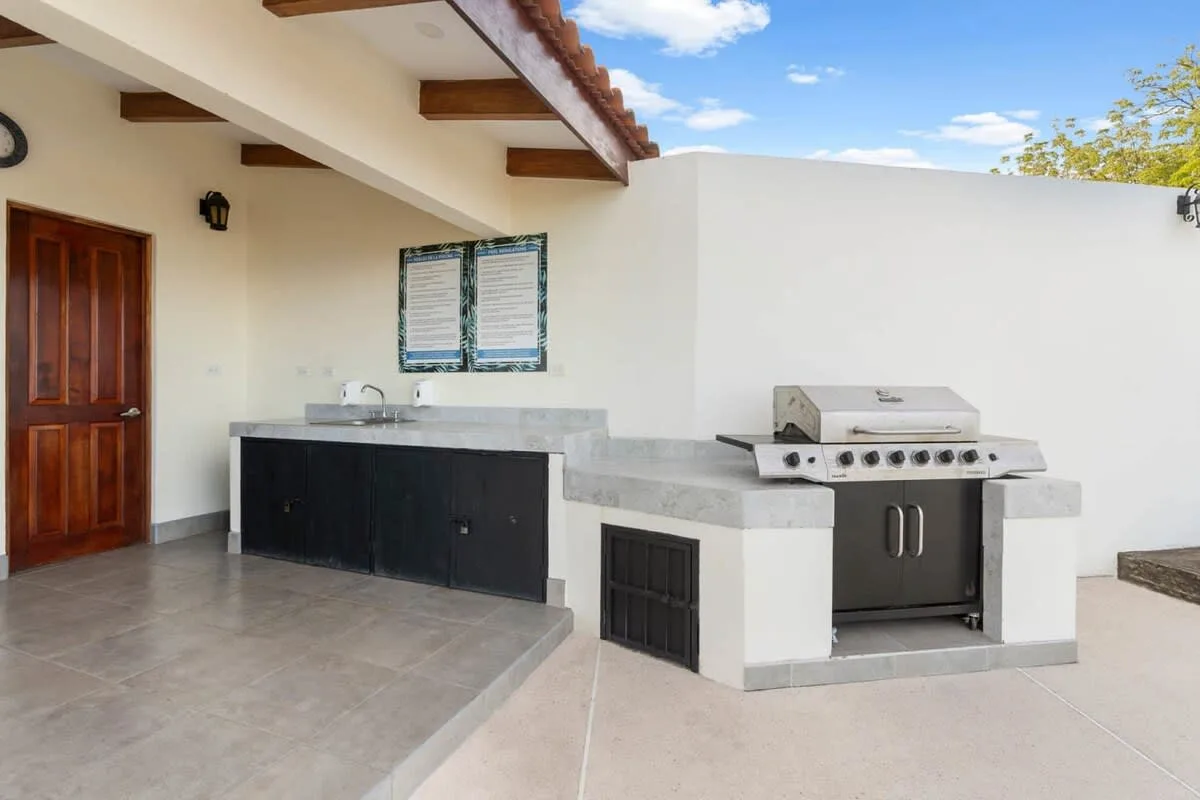 Shared amenity: An outdoor kitchen area with a counter, sink, and built-in grill.