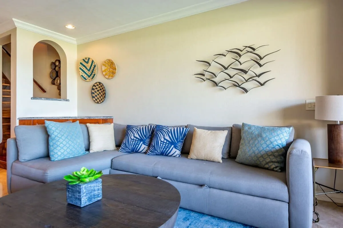 A living room with a sectional sofa, decorative wall art, and a coffee table.