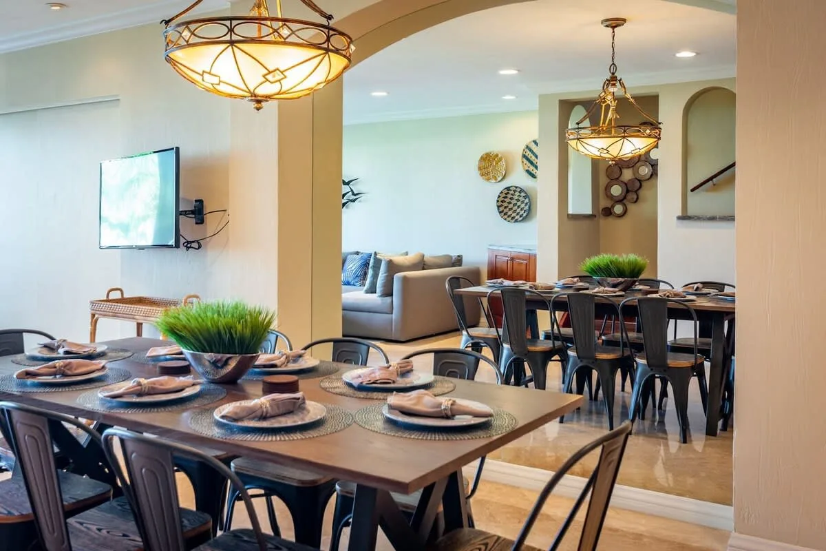 An open dining area with a long table and a lounge seating area beyond.