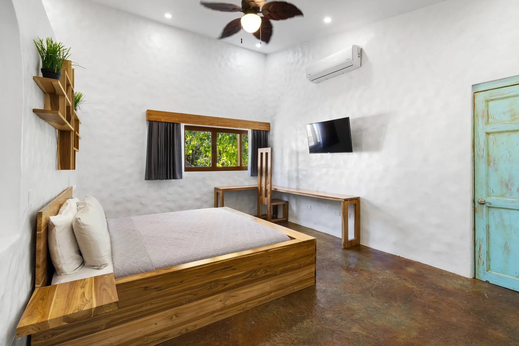 Un dormitorio con una cama de madera, una ventana y un televisor en la pared.