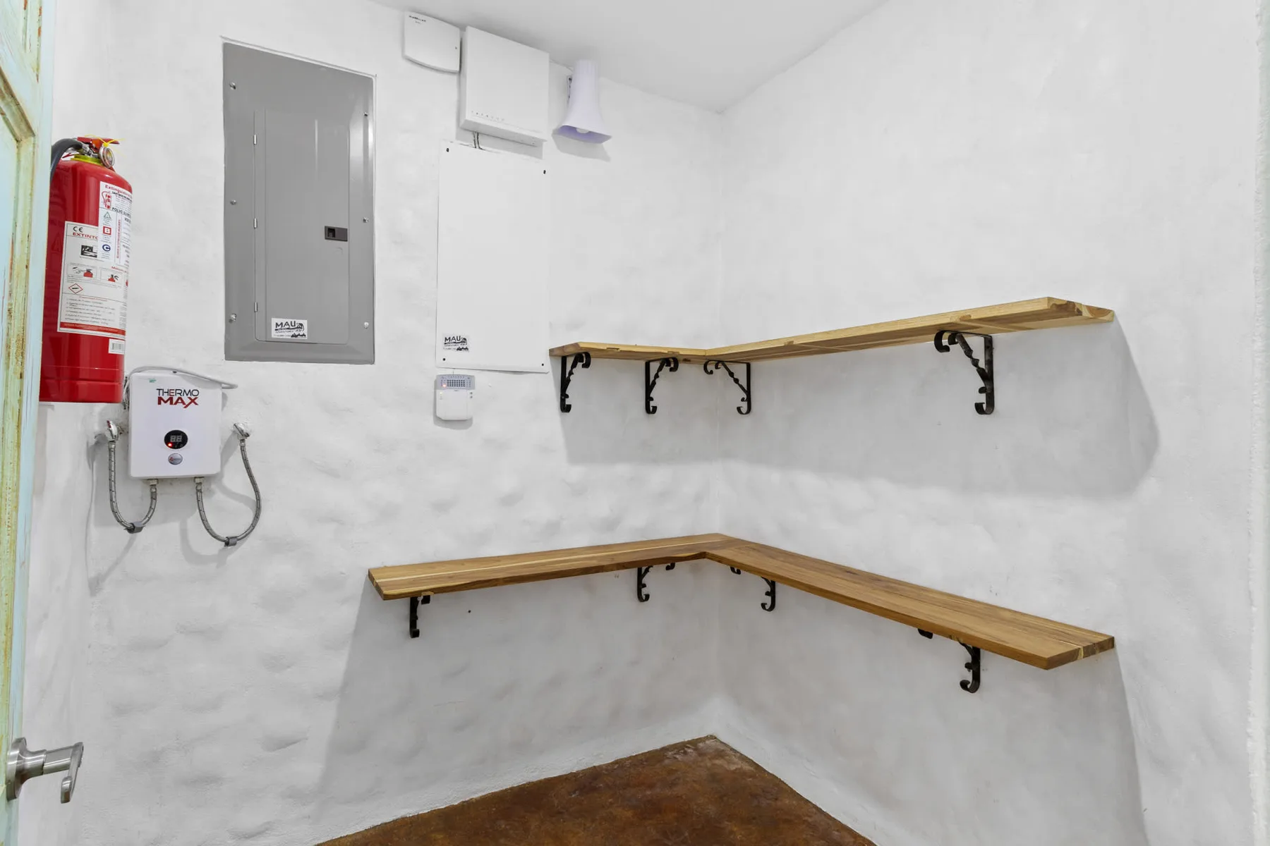 Un pequeño cuarto de servicio con estantes de madera en la pared y equipo eléctrico.